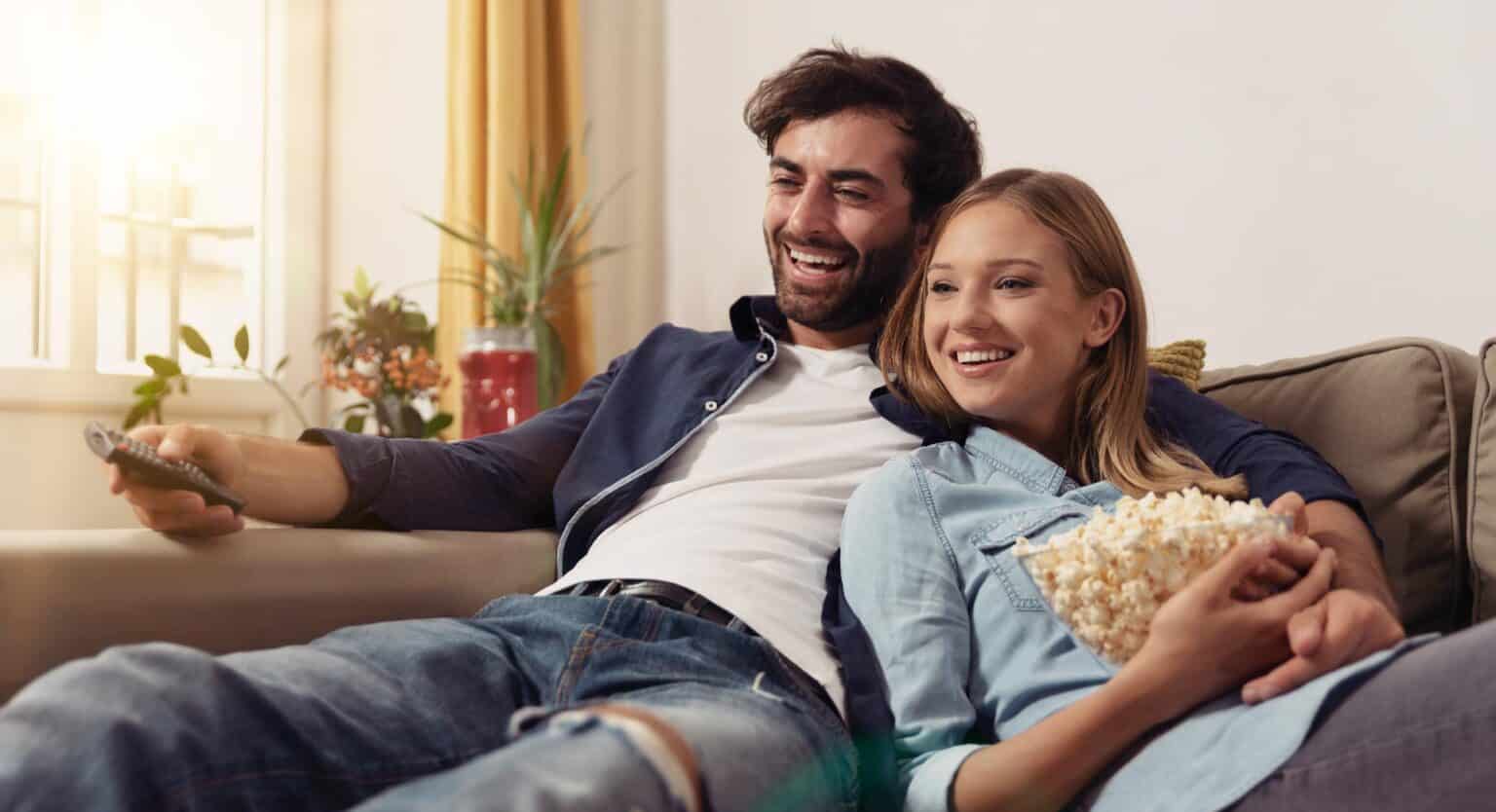 Ein Paar, das auf der Couch sitzt und fern schaut