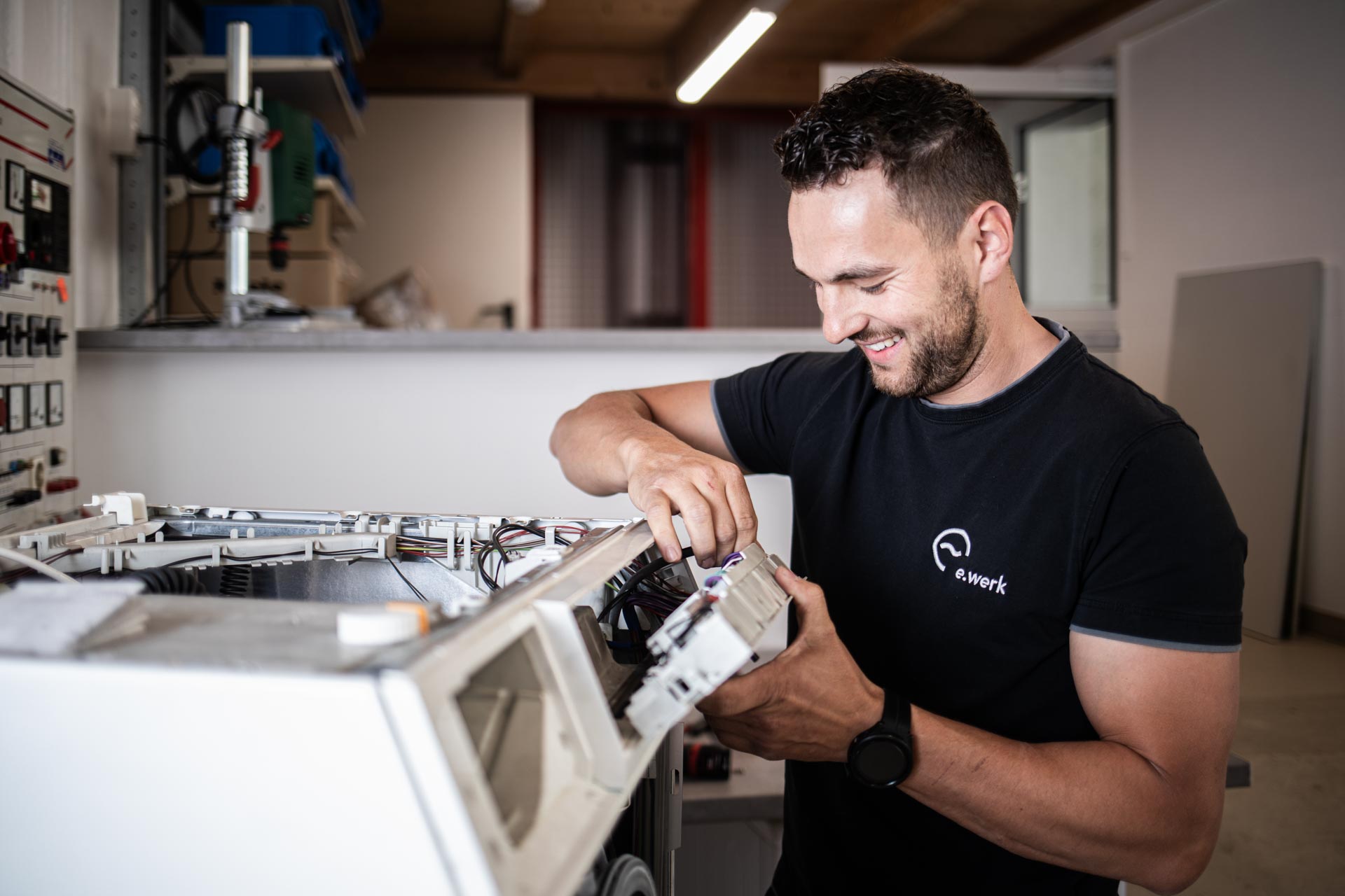 Facharbeiter des E-Werk Hopfgarten beim Tausch eines defekten Bauteiles an einer Waschmaschine